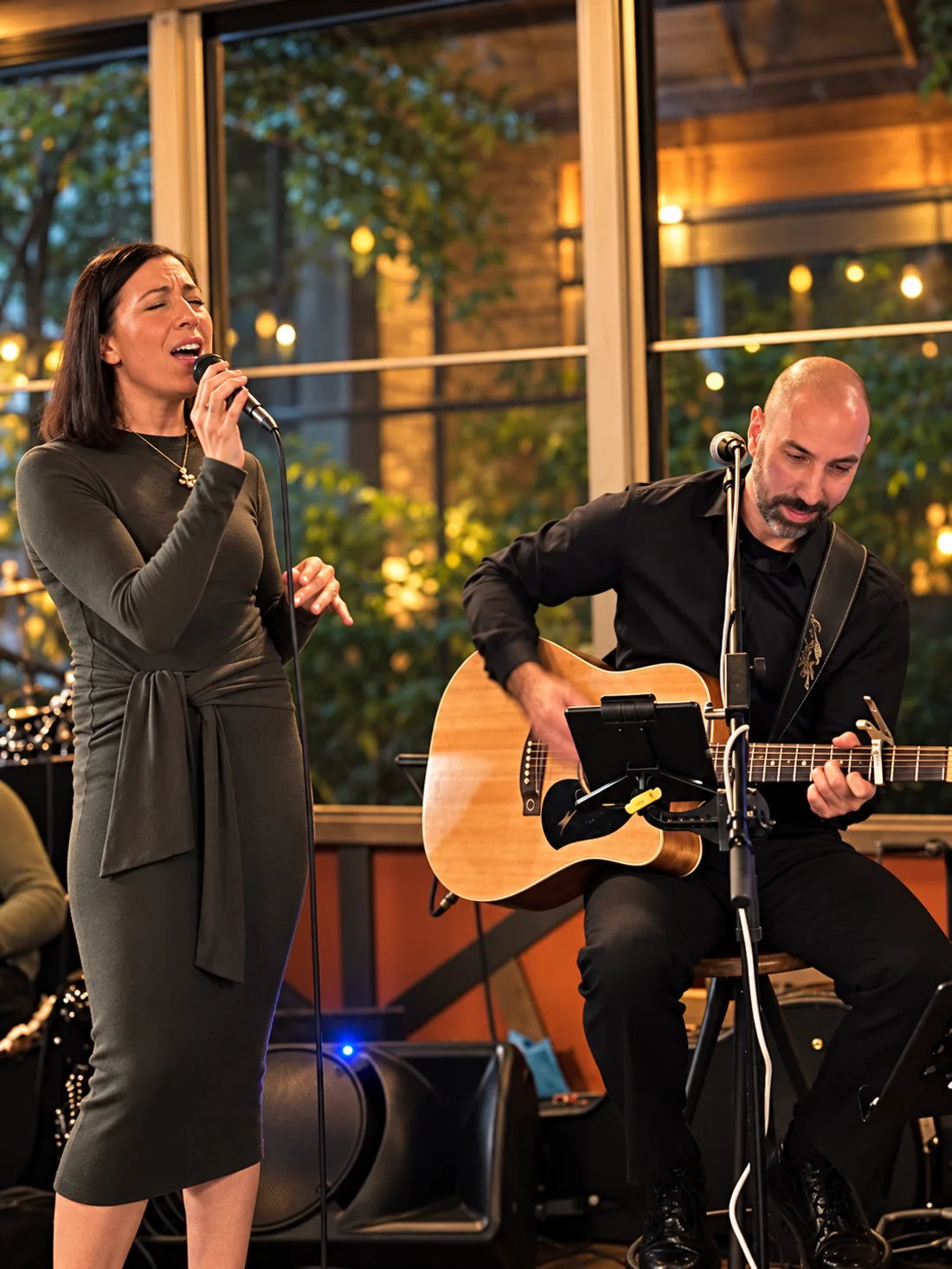 Dan playing guitar alongside vocalist Natalia during an acoustic duo performance